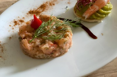 Petits plats individuels contenant purée, morceaux de viande en sauce et cuillères en bois, disposés sur un plateau.