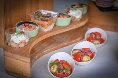 Petits plats individuels contenant purée, morceaux de viande en sauce et cuillères en bois, disposés sur un plateau.