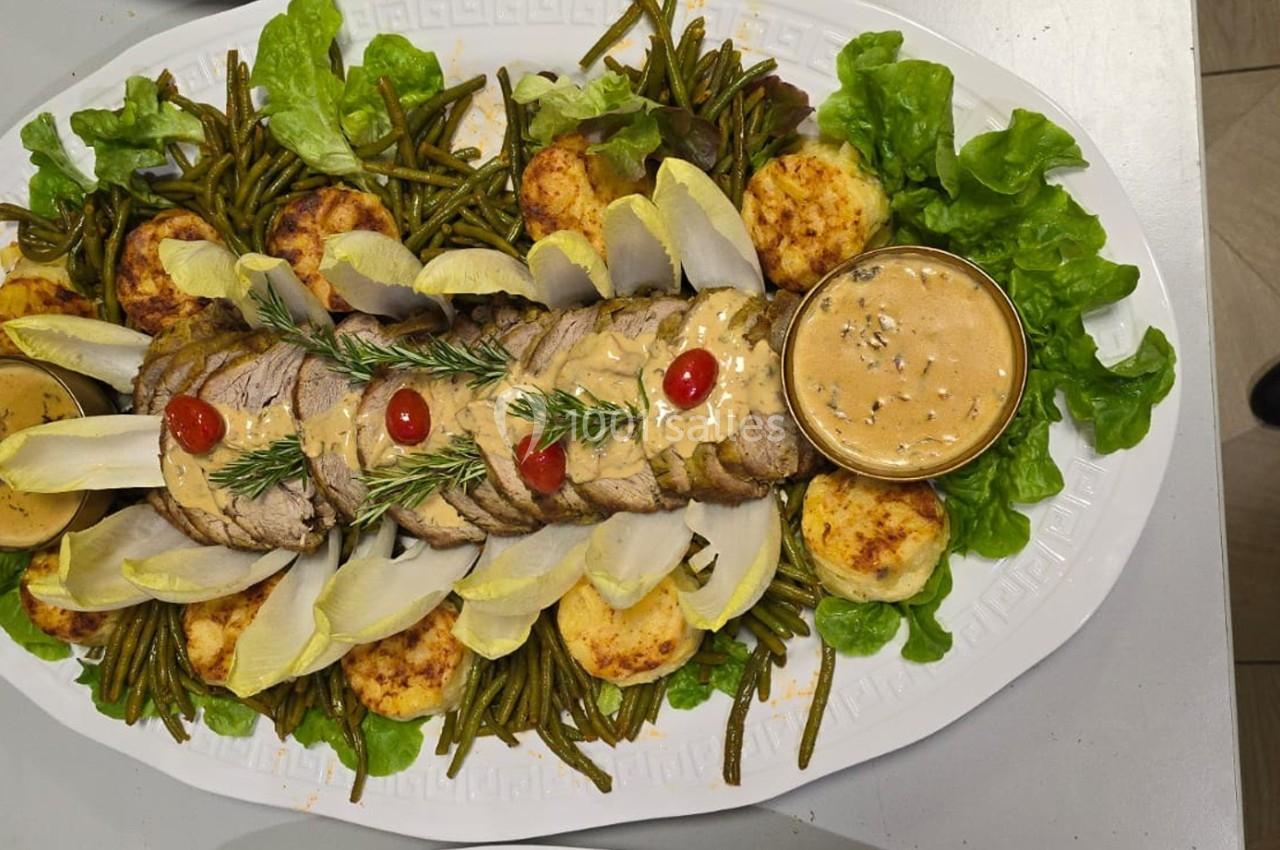 Plat de viande tranchée garni de sauce, haricots verts, endives, pommes de terre gratinées et salade verte.