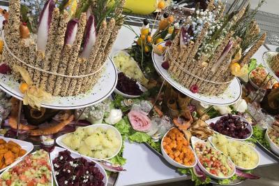 Assiette garnie d'un jarret d'agneau en sauce, accompagnée de légumes, fruits confits et d'une décoration en œuf et cerise.