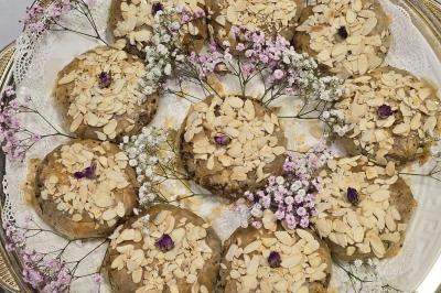 Assiette garnie d'un jarret d'agneau en sauce, accompagnée de légumes, fruits confits et d'une décoration en œuf et cerise.