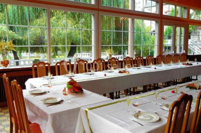 Salle de bain moderne avec carrelage gris, lavabo, toilettes et fenêtre laissant entrer la lumière naturelle.