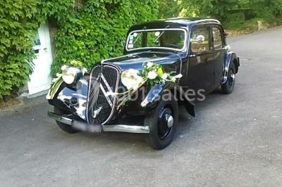 Salle de bain moderne avec carrelage gris, lavabo, toilettes et fenêtre laissant entrer la lumière naturelle.
