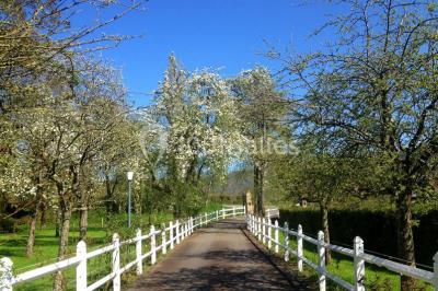 Salle de bain moderne avec carrelage gris, lavabo, toilettes et fenêtre laissant entrer la lumière naturelle.