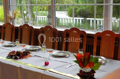 Salle de bain moderne avec carrelage gris, lavabo, toilettes et fenêtre laissant entrer la lumière naturelle.