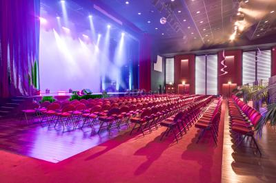 Salle avec structures gonflables colorées, tables, chaises et stands installés pour un événement intérieur.