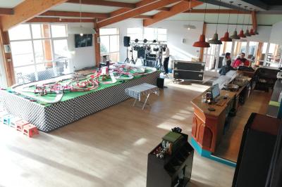 Circuit de course miniature avec des pistes sinueuses, des décors et des structures sur une table dans une salle.