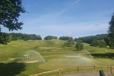 Circuit de course miniature avec des pistes sinueuses, des décors et des structures sur une table dans une salle.