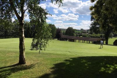 Circuit de course miniature avec des pistes sinueuses, des décors et des structures sur une table dans une salle.