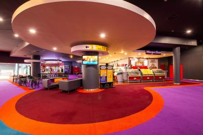 Miniature Location salle Nice (Alpes-Maritimes) - Pathé Lingostiere #2 Salle de cinéma vide avec des rangées de fauteuils rouges et un écran illuminé en arrière-plan.