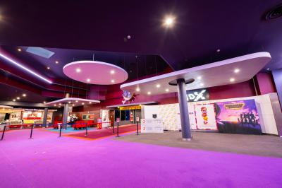 Miniature Location salle Nice (Alpes-Maritimes) - Pathé Lingostiere #8 Salle de cinéma vide avec des rangées de fauteuils rouges et un écran illuminé en arrière-plan.