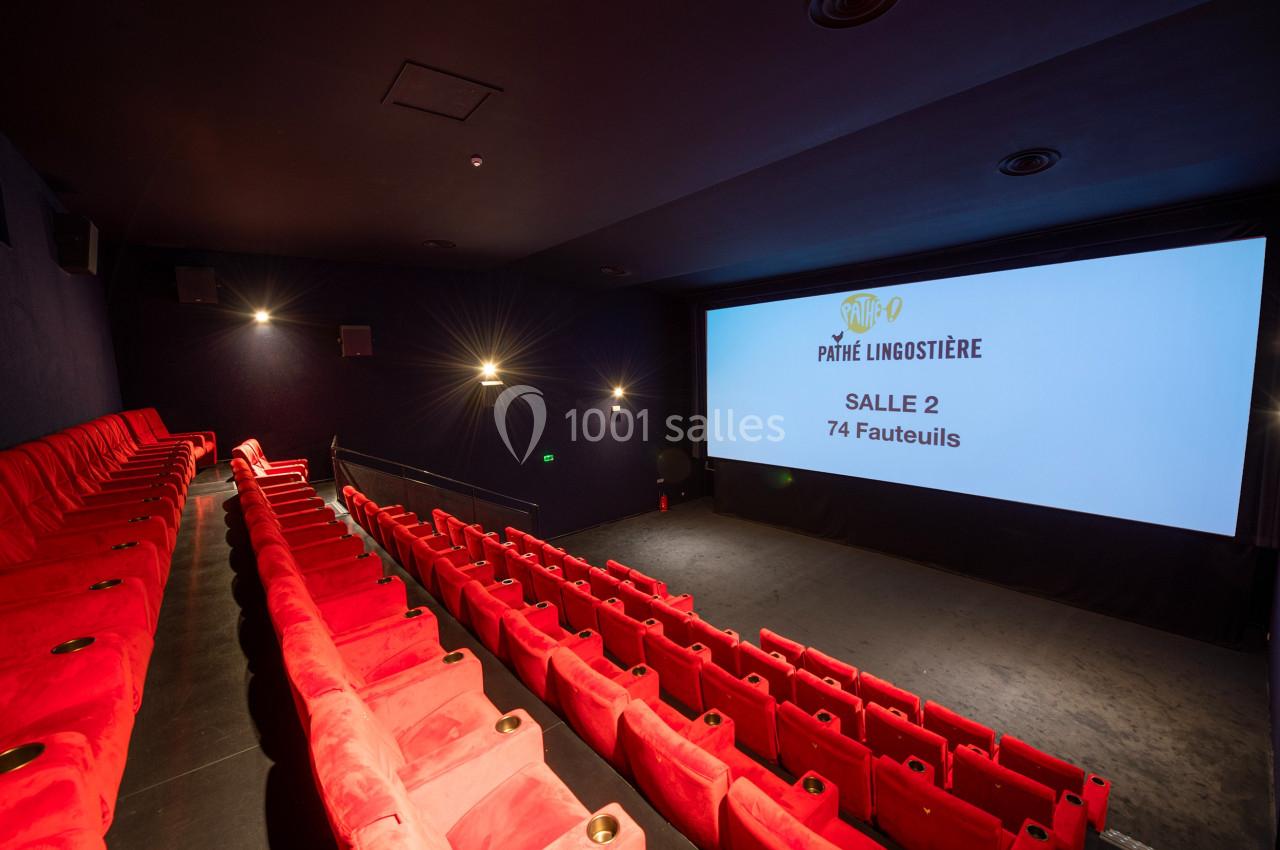 Salle de cinéma avec des rangées de fauteuils rouges et un écran affichant ’Pathé Lingostière, Salle 2, 74 fauteuils’.