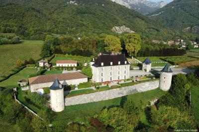 Fontaines jaillissantes devant des bâtiments historiques avec des montagnes enneigées en arrière-plan.