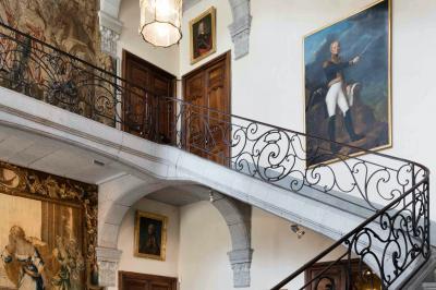 Fontaines jaillissantes devant des bâtiments historiques avec des montagnes enneigées en arrière-plan.