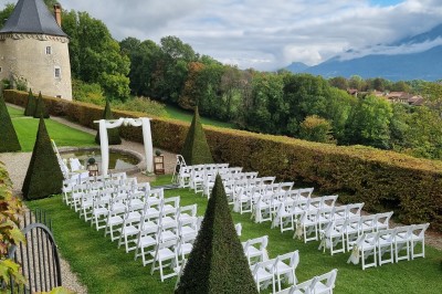 Salle élégante avec moulures, lustres, peintures anciennes et une table dressée avec verres et décorations florales.