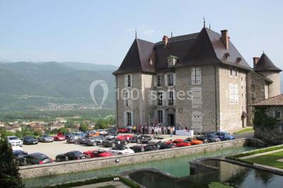 Fontaines jaillissantes devant des bâtiments historiques avec des montagnes enneigées en arrière-plan.