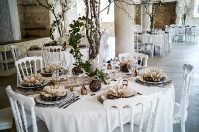 Un grand groupe de personnes posant devant un bâtiment historique en pierre avec des fenêtres et des balcons.
