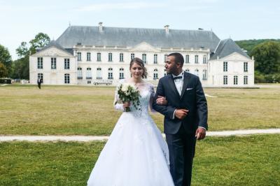 Un grand groupe de personnes posant devant un bâtiment historique en pierre avec des fenêtres et des balcons.