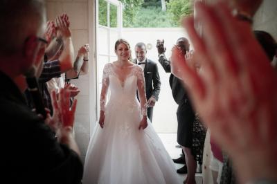 Un grand groupe de personnes posant devant un bâtiment historique en pierre avec des fenêtres et des balcons.
