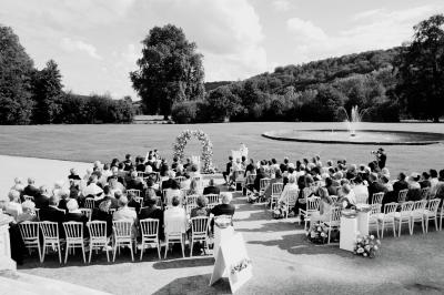 Un grand groupe de personnes posant devant un bâtiment historique en pierre avec des fenêtres et des balcons.