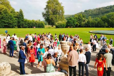 Un grand groupe de personnes posant devant un bâtiment historique en pierre avec des fenêtres et des balcons.