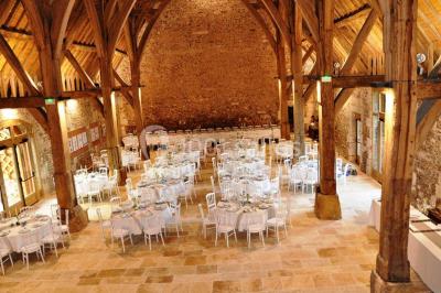 Chemin de gravier bordé d'herbe et d'arbres, avec des voitures garées en arrière-plan sous un ciel nuageux.
