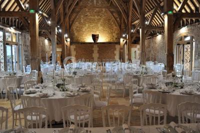 Chemin de gravier bordé d'herbe et d'arbres, avec des voitures garées en arrière-plan sous un ciel nuageux.