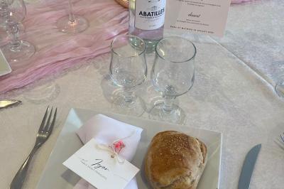Salle de réception élégante avec tables décorées de fleurs blanches, chaises transparentes et éclairage tamisé.