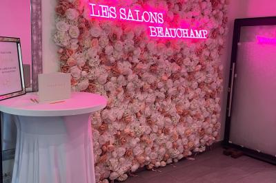 Salle de réception élégante avec tables décorées de fleurs blanches, chaises transparentes et éclairage tamisé.