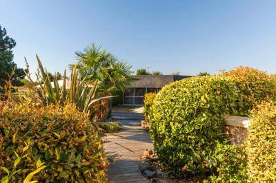 Salle de bain moderne avec douche à l'italienne, lavabo avec miroir, radiateur sèche-serviettes et carrelage clair.