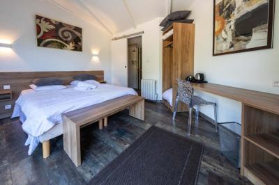 Salle de bain moderne avec douche à l'italienne, lavabo avec miroir, radiateur sèche-serviettes et carrelage clair.