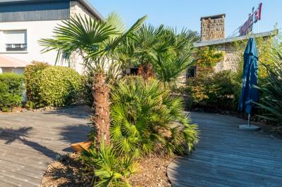 Salle de bain moderne avec douche à l'italienne, lavabo avec miroir, radiateur sèche-serviettes et carrelage clair.
