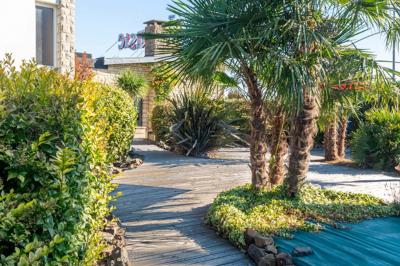 Salle de bain moderne avec douche à l'italienne, lavabo avec miroir, radiateur sèche-serviettes et carrelage clair.