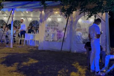 Buffet en plein air avec une variété de plats et boissons, installé sous une tente lors d'un événement convivial.