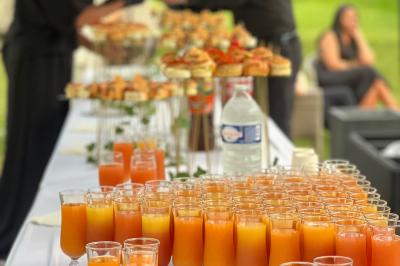Buffet en plein air avec une variété de plats et boissons, installé sous une tente lors d'un événement convivial.