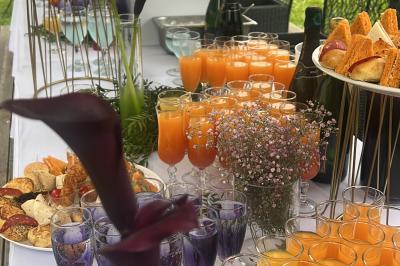 Buffet en plein air avec une variété de plats et boissons, installé sous une tente lors d'un événement convivial.