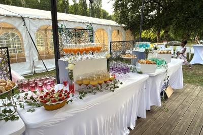 Buffet en plein air avec une variété de plats et boissons, installé sous une tente lors d'un événement convivial.