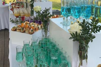 Buffet en plein air avec une variété de plats et boissons, installé sous une tente lors d'un événement convivial.