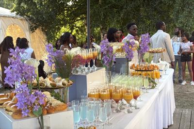 Buffet en plein air avec une variété de plats et boissons, installé sous une tente lors d'un événement convivial.
