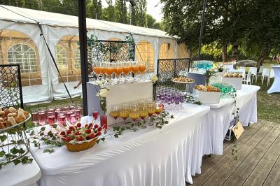Buffet en plein air avec une variété de plats et boissons, installé sous une tente lors d'un événement convivial.