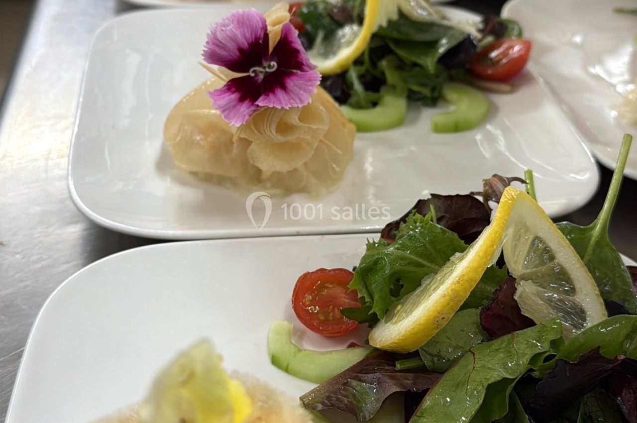 Assiettes garnies de croustillants en pâte filo et de salades fraîches avec tomates, citron et fleurs comestibles.