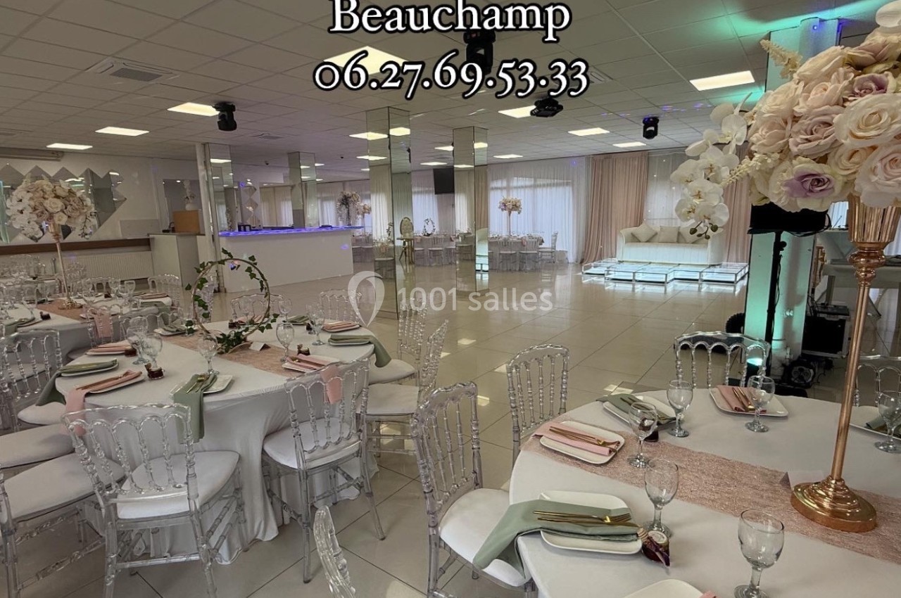 Salle de réception élégante avec tables décorées de nappes blanches, chaises transparentes et arrangements floraux.