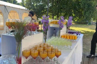Buffet en plein air avec une variété de plats et boissons, installé sous une tente lors d'un événement convivial.
