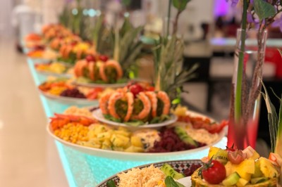 Buffet en plein air avec une variété de plats et boissons, installé sous une tente lors d'un événement convivial.