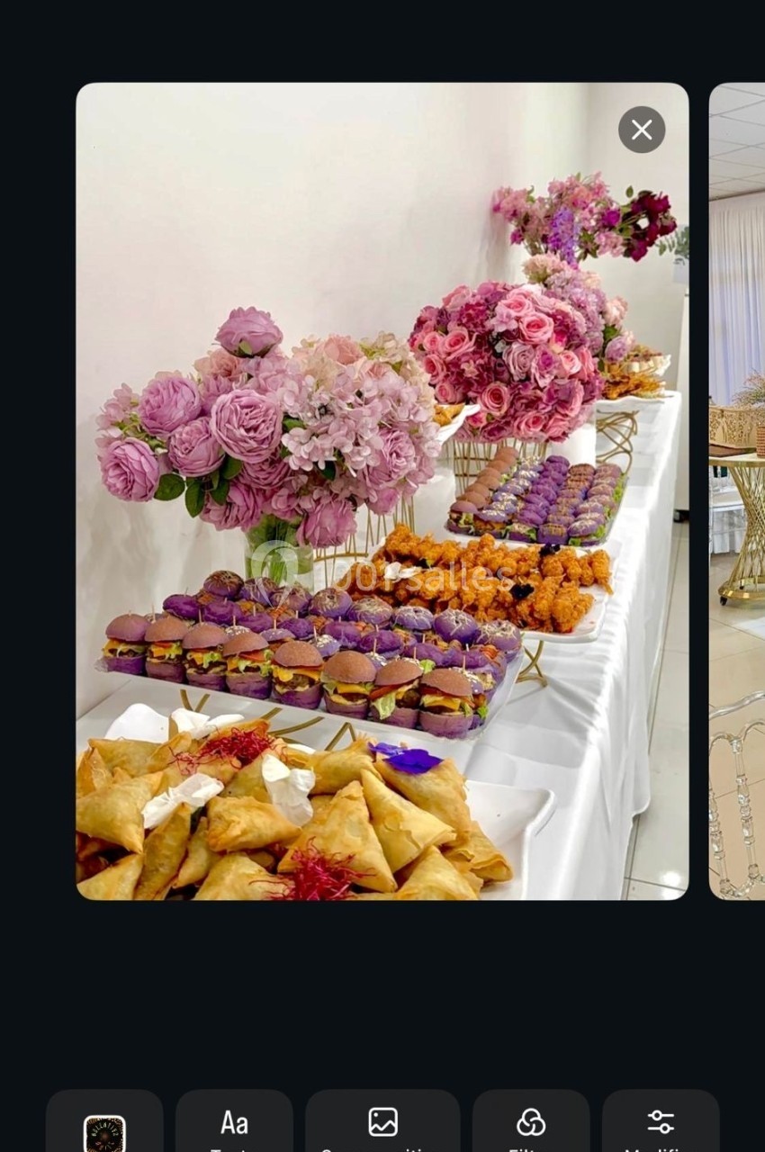 Table garnie de pâtisseries variées et de fleurs roses en décoration dans un cadre élégant.