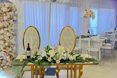 Miniature Location salle Beauchamp (Val-d'Oise) - L'instant Gourmand #3 Tente blanche avec tables hautes décorées de fleurs, installée sur une pelouse entourée d'arbres au printemps.