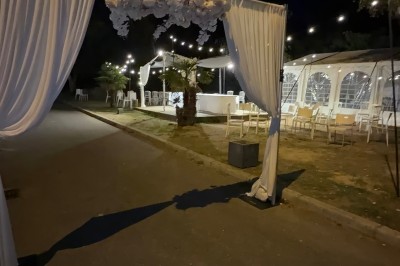 Salle de réception élégante avec tables dressées, chaises transparentes et décoration florale raffinée.