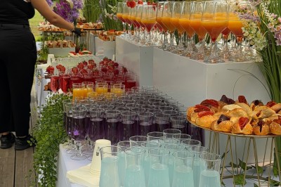 Salle de réception élégante avec tables dressées, chaises transparentes et décoration florale raffinée.