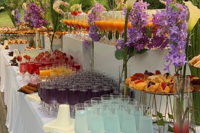 Salle de réception élégante avec tables dressées, chaises transparentes et décoration florale raffinée.