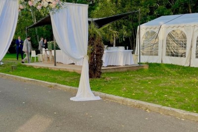 Salle de réception élégante avec tables dressées, chaises transparentes et décoration florale raffinée.